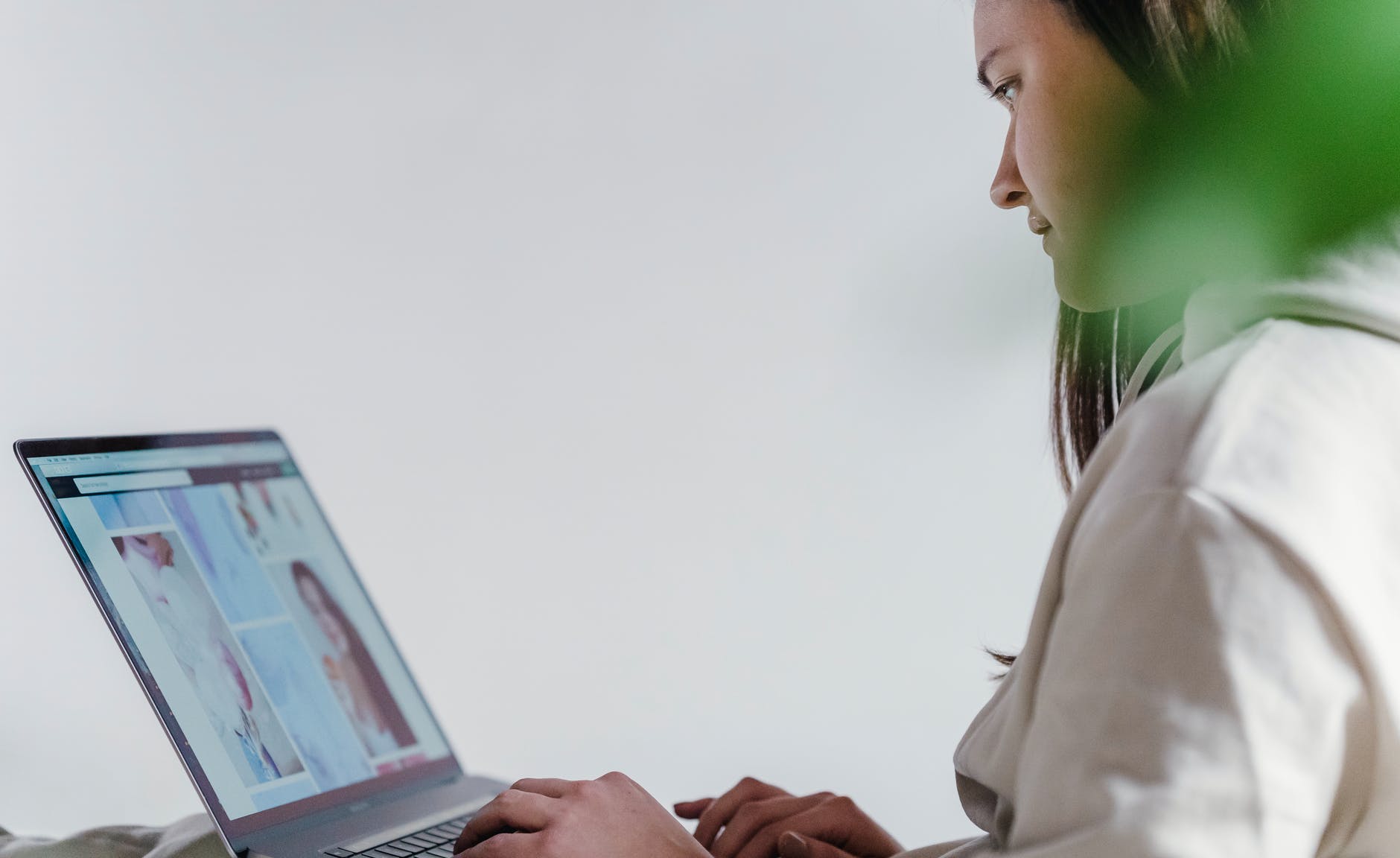 crop woman browsing laptop in room